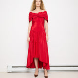 Discover the Vintage Red Dress with Flower Detail – a size 8 asymmetrical dress with 44-55 inch length and 16.5-inch shoulders. In good vintage condition, modeled by someone 5'11" tall.