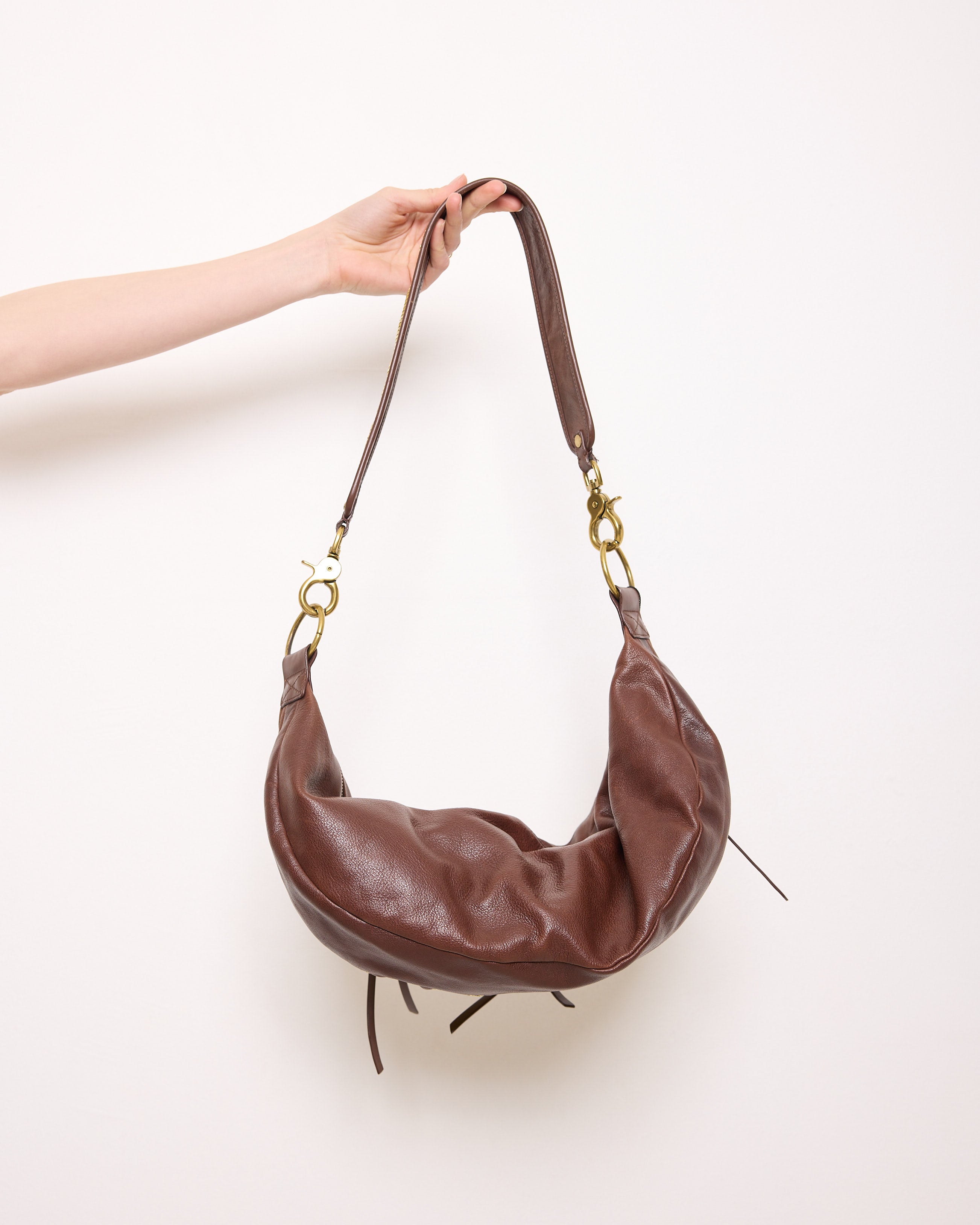 Brown leather shoulder bag with gold mesh details, 7x19 inches, 17-inch strap, multi-pocket design