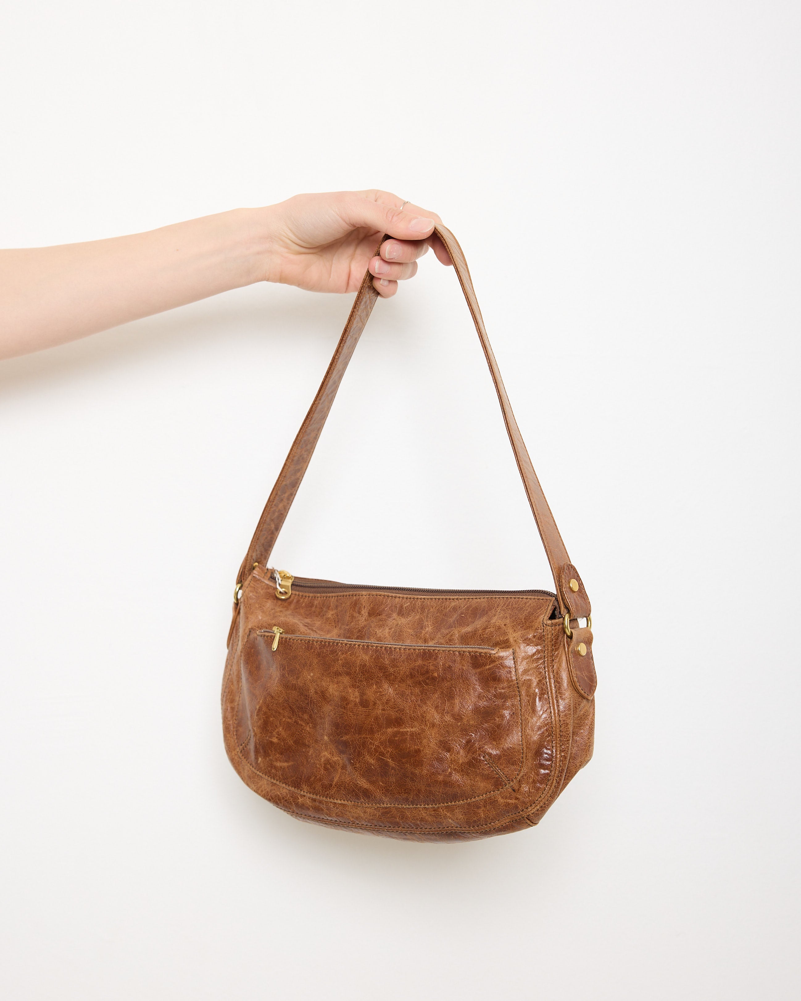 Vintage slouchy brown leather shoulder bag with gold-tone zipper and wide flat strap, shown front and back