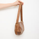 Vintage slouchy brown leather shoulder bag with gold-tone zipper and wide flat strap, shown front and back