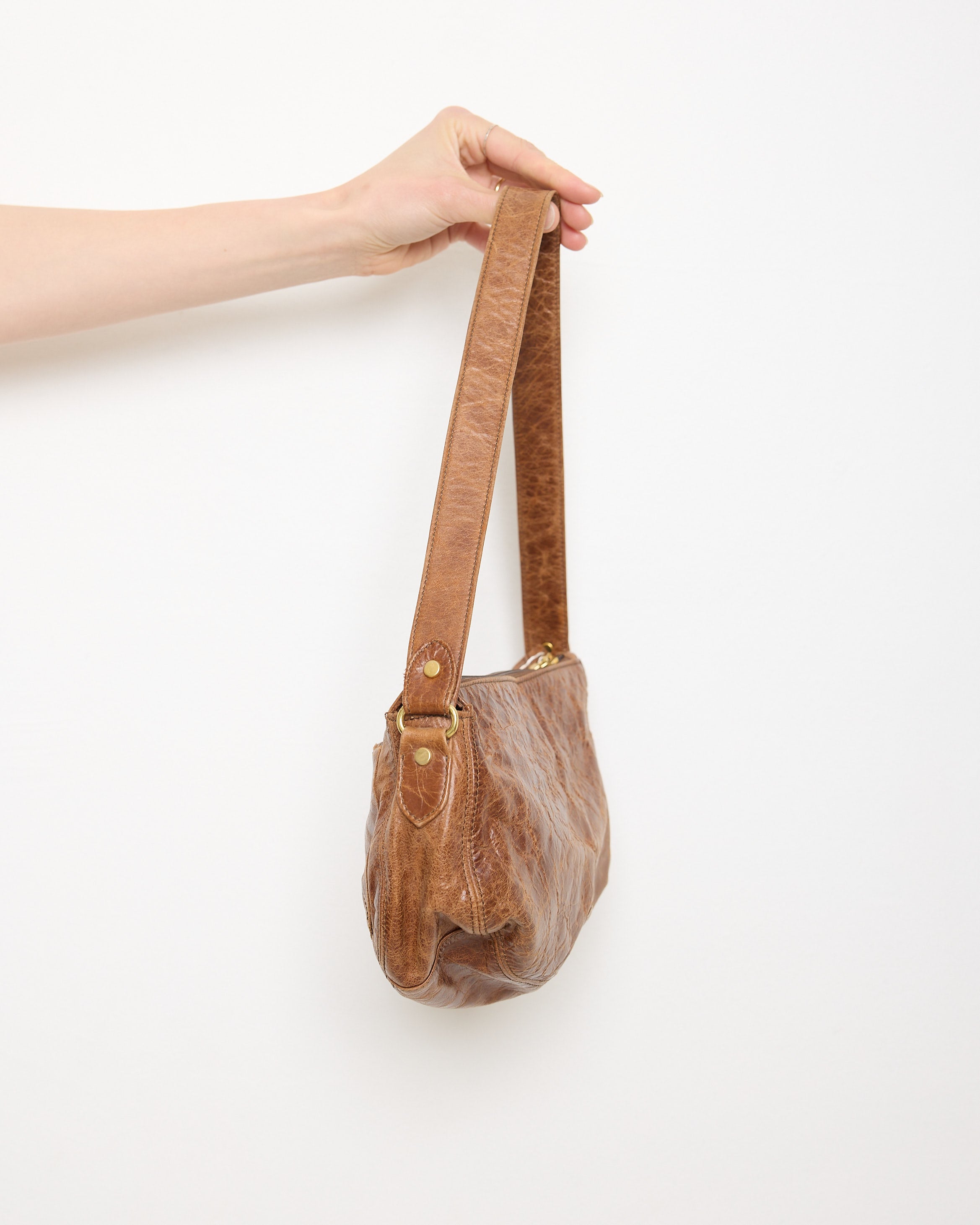 Vintage slouchy brown leather shoulder bag with gold-tone zipper and wide flat strap, shown front and back