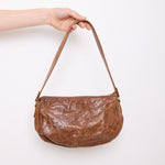 Vintage slouchy brown leather shoulder bag with gold-tone zipper and wide flat strap, shown front and back