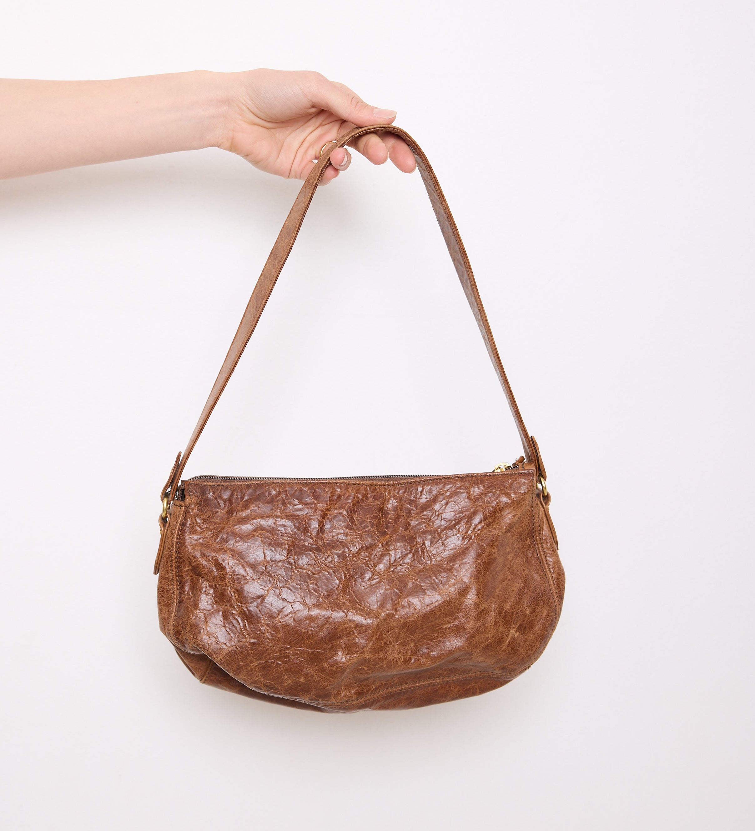 Vintage slouchy brown leather shoulder bag with gold-tone zipper and wide flat strap, shown front and back
