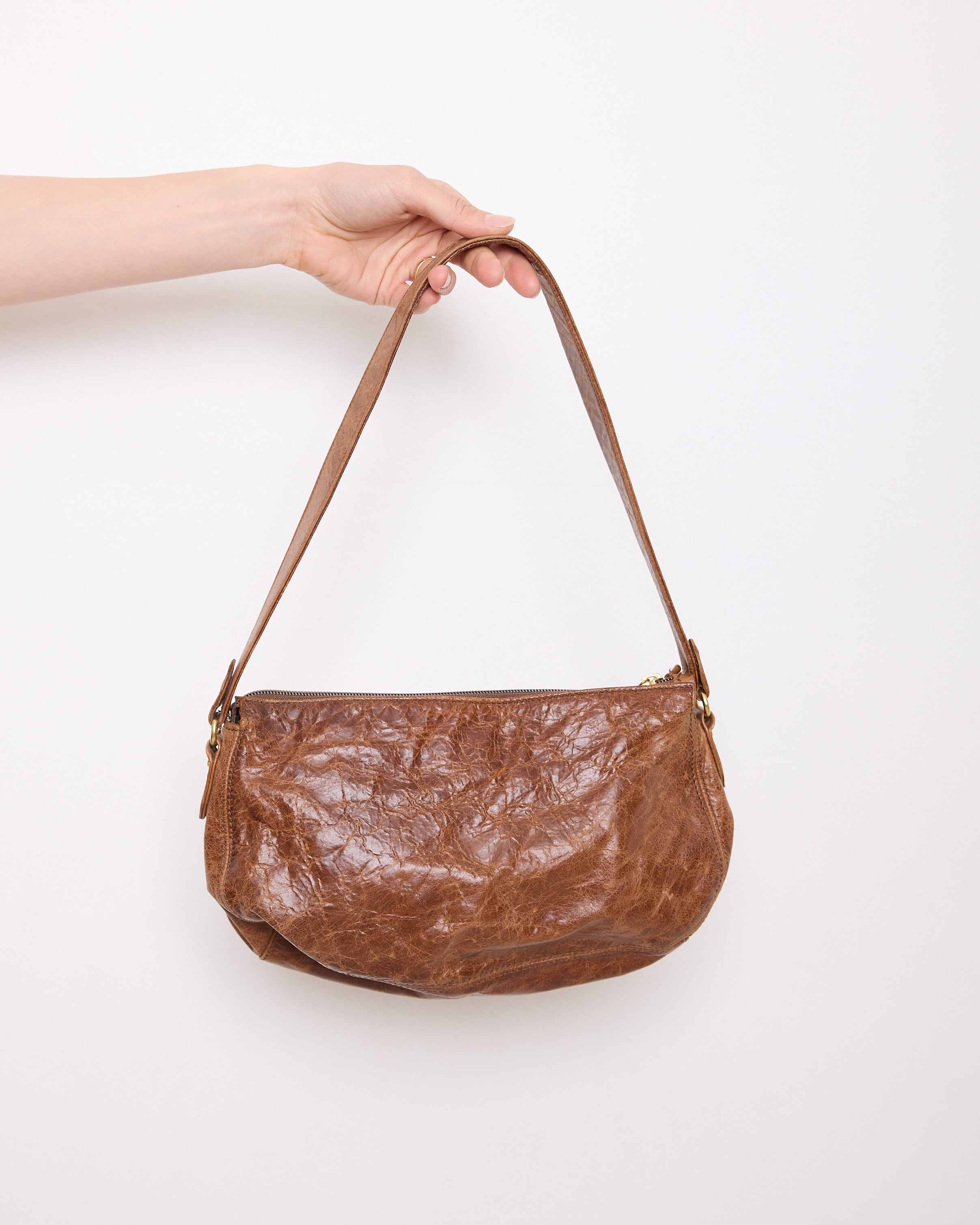 Vintage slouchy brown leather shoulder bag with gold-tone zipper and wide flat strap, shown front and back