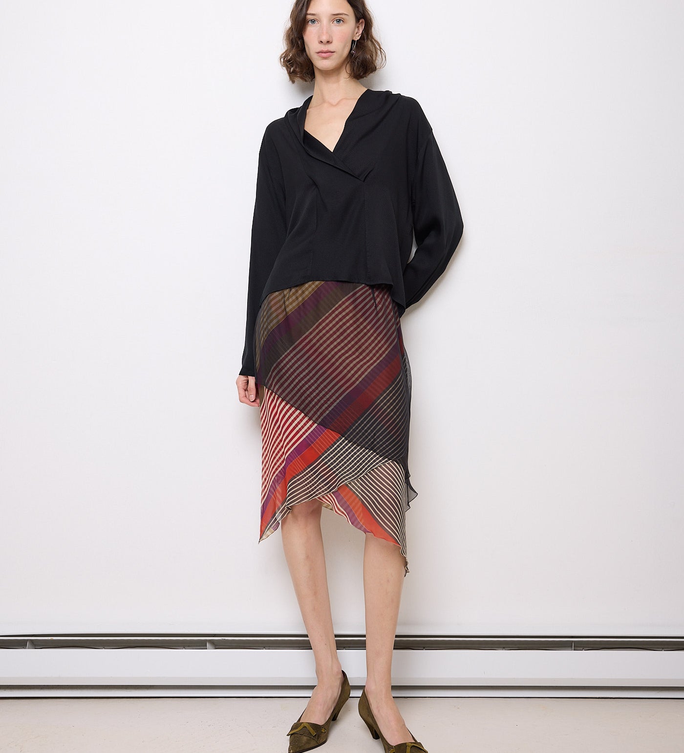 Vintage Etro silk skirt with multicolor diagonal stripe print and asymmetrical hem, worn by model in black blouse.