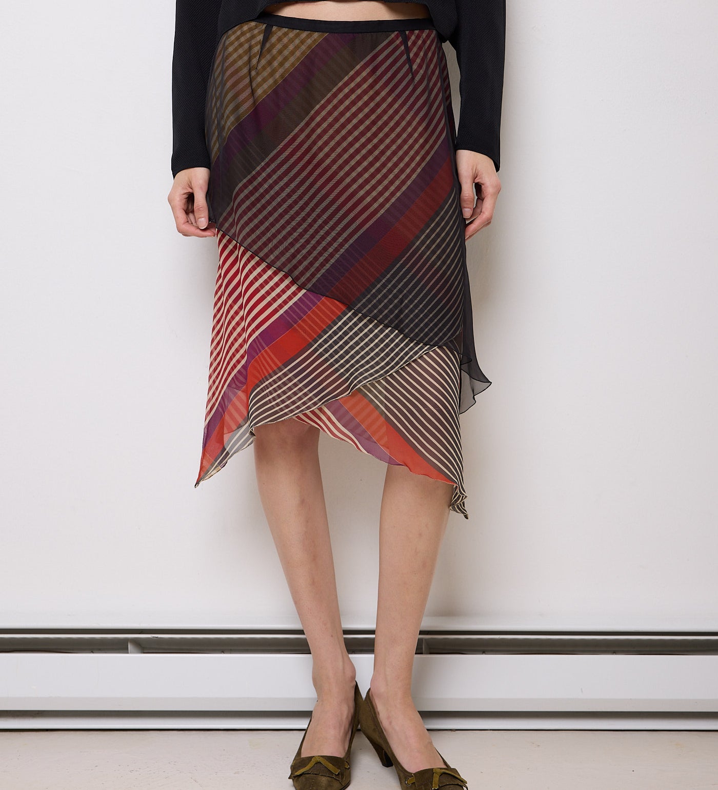 Vintage Etro silk skirt with multicolor diagonal stripe print and asymmetrical hem, worn by model in black blouse.